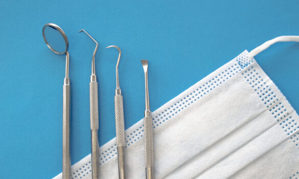 Picture of a surgical mask and four dental tools.